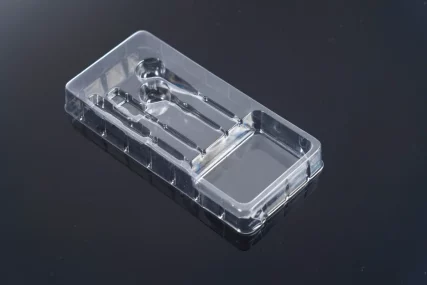 Clear plastic blister pack with molded slots for two spoons on a black background.