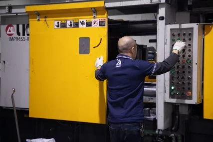 worker operating die casting machine